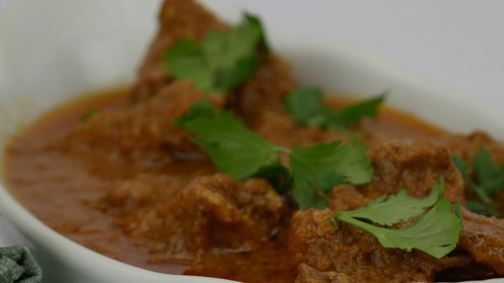 Lamb Curry · Slow cooked chunks of lamb cooked in a special gravy and spices, served with rice, bread and salad.