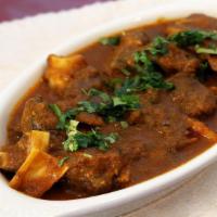 Goat Curry (Bone In) · Served with rice.