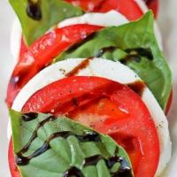 Caprese Salad · Vine-ripened tomato and fresh mozzarella, served over fresh field greens and drizzled with e...
