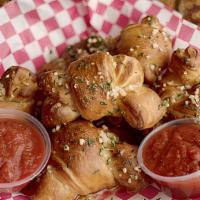 Garlic Knots · Hand-tied knots drenched in fresh garlic butter with red sauce for dipping