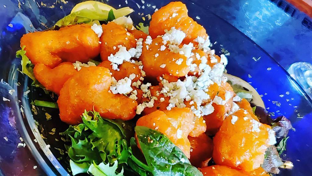 Buffalo Cauliflower · Deep-fried cauliflower bites tossed in a signature buffalo sauce and topped with blue cheese crumbles.