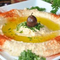 Traditional Hummus · Tasty blend of garbanzo beans, garlic, lemon juice and sesame seed paste topped with olives,...