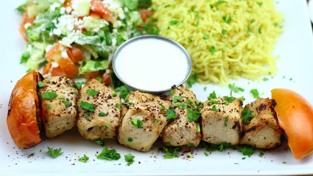 Chicken Shish Kabob · Tender chunks of boneless chicken breast marinated in special yogurt sauce and herbs char-grilled to perfection served with basmati rice, house feta salad, grilled tomatoes, creamy garlic sauce and a warm homemade pita bread
