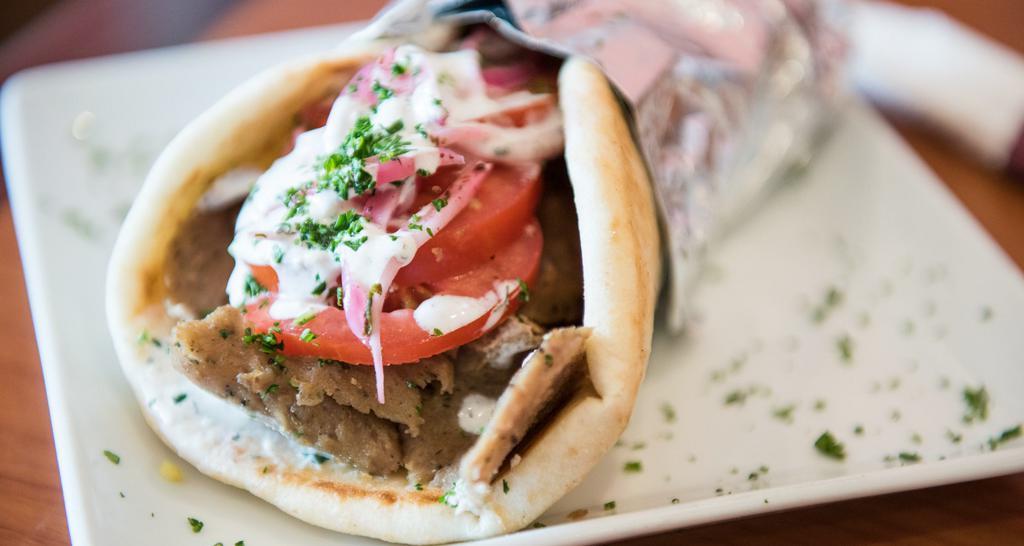 Gyro Wrap · Juicy tender, lean blends of beef and lamb seasoned with zesty Greek spices, roasted on vertical “spit” wrapped in pita with fresh seasoned onions, tomatoes, parsley and topped with our home-made tzatziki sauce.