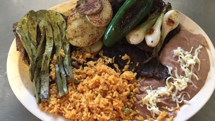 Carne Asada · Servido con arroz, frijoles, papas, cactus, cebollas a la parrilla y jalapeños. / Served with rice, beans, potatoes, cactus, grilled onions and jalapeños.