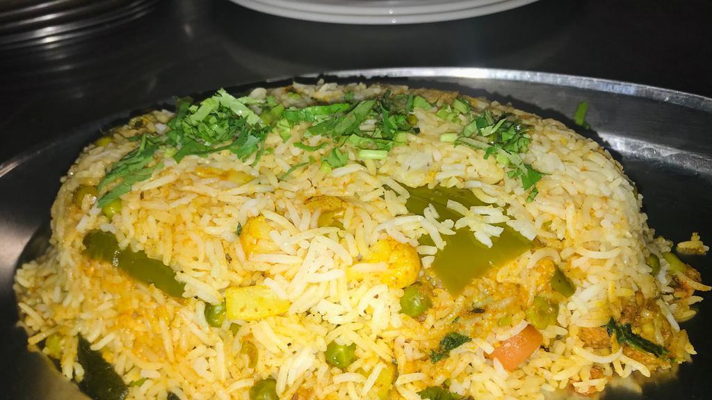 Vegetable Dum Biryani · Basmati rice cooked with mixed vegetables, a blend of herbs and saffron. Served with yogurt raita.