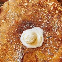 Pancakes · Three large pancakes served with a side of whipped butter and syrup.