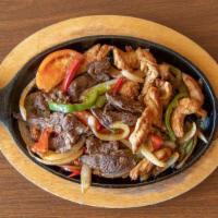 Combo Fajitas · Beef and chicken on a bed of sautéed onions, tomatoes, red and green peppers.