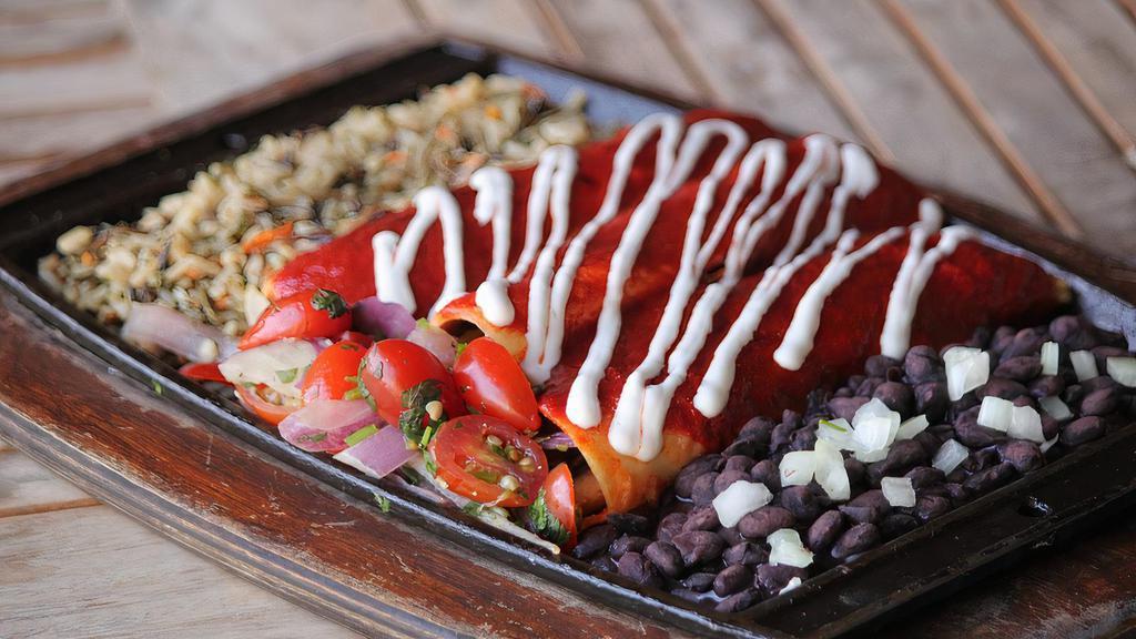 Vegan Enchiladas · Sautéed red & green bell peppers,
onions, mushrooms, vegan Cheddar
cheese wrapped up in three thick corn
tortillas, smothered in red or green
enchilada sauce. Served with vegan
sour cream, cherry tomato pico de
gallo, black beans & wild rice. vegan