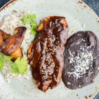 Pollo Mole Poblano · Grilled chicken breast, mole poblano sauce, fried plantains, epazote herb rice, refried beans.