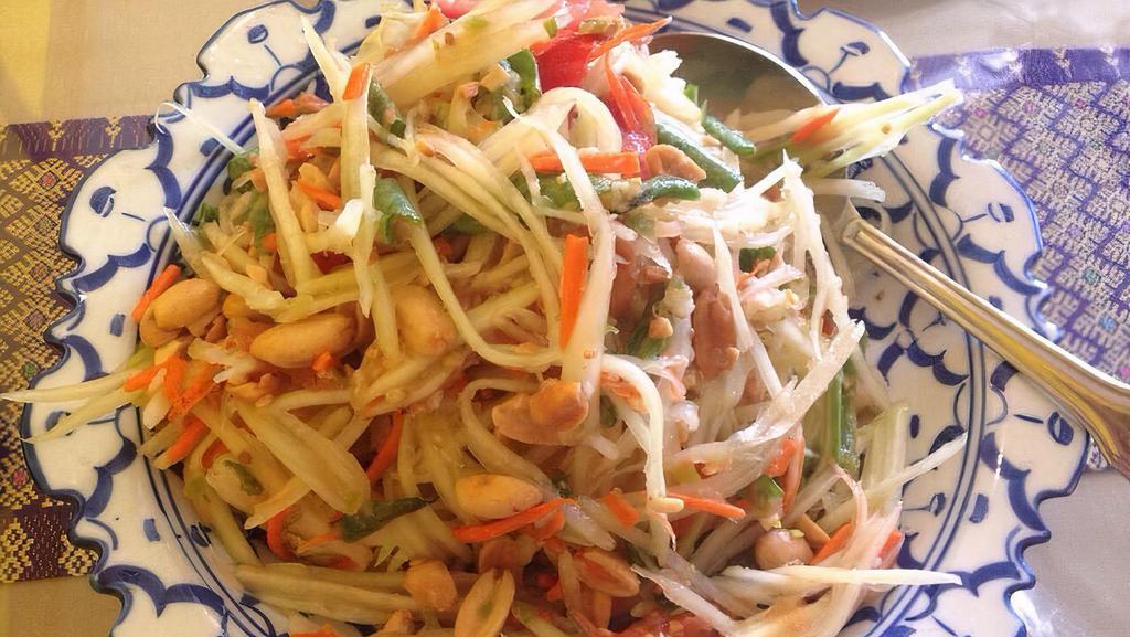 Papaya Salad / Som Tum · This salad captures the essential flavor of Thailand. Fine shredded green papaya, tossed with shrimp, tomatoes, ground peanut & hot chili.