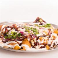 Samosa Chaat · An open samosa mixed and served with masala, chutney, and spices