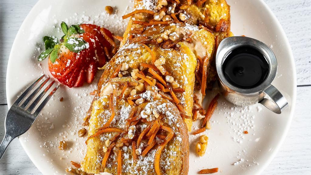 Carrot Cake Stuffed French Toast · Cinnamon egg-dipped artisan bread grilled + filled w/sweet ricotta cream cheese, topped w/ a maple-cinnamon carrot + toasted walnut compote + served w/warm syrup.
