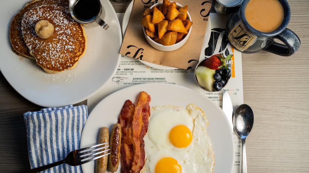 T'S Two For You · Two buttermilk pancakes w/maple cinnamon butter + syrup, two cage-free eggs any style, two nitrate-free hickory-smoked bacon strips, two pork sausage links + crispy home fries.