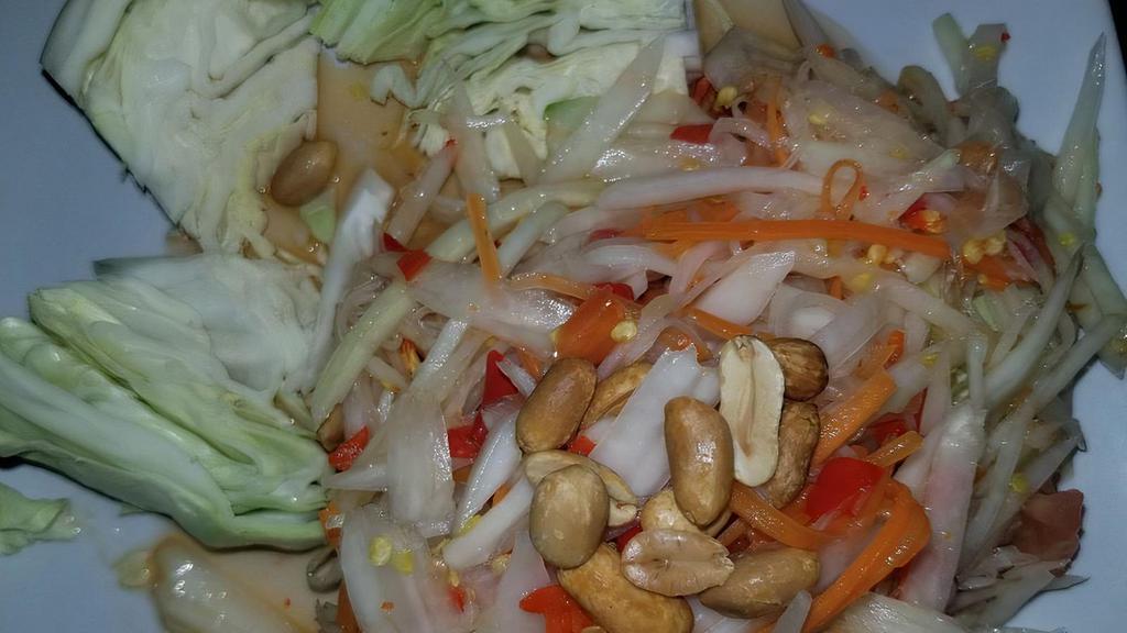 Papaya Salad · Shredded green papaya with tomato, garlic, carrot, and peanuts in lime sauce. Served with cabbage.
