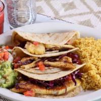 Fish Tacos · Three homemade corn tortillas stuffed with cabbage and grilled tilapia. Served with rice. ch...