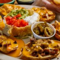 Papa Nachos · Six potato skins topped with chile con queso, guacamole, sour cream, and jalapeños with gril...