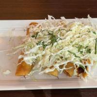 Taquitos Dorados · Fried tortilla stuffed with chicken with refried beans, fresh cheese cabbage, and sour cream.