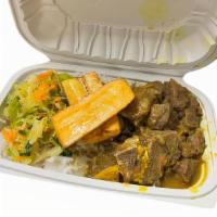 Curry Goat · Bone in goat meat cooked tender. Served with rice and peas and sautéed cabbage