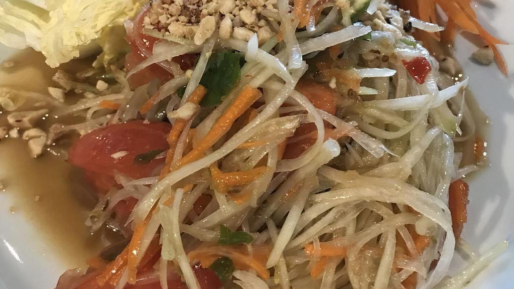 Thai Papaya Salad · Spicy, vegetarian. The Thai papaya salad is what Thailand is known for, shredded papaya and carrots, tomatoes, lime, roasted peanuts, with a spicy kick and  cabbages on the side. Please note spiciness level, if no spiciness level is noted, it will be mild.