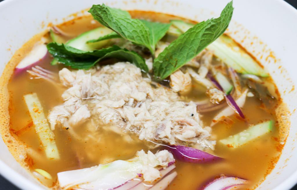 Penang Assam Laksa Noodle Soup · Noodle soup with tuna in sweet, spicy and sour broth topped with cucumber, fresh onions, and mint leaves.
