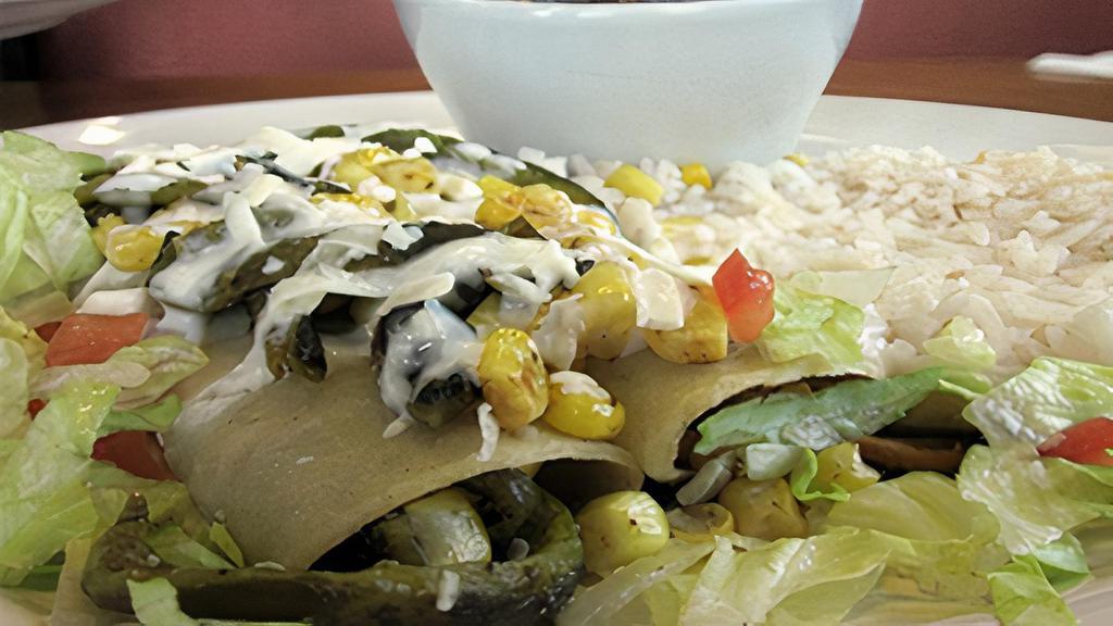 Enchiladas Dona Irene · 2 corn and poblano pepper enchiladas, covered with Mx cream, and queso fresco. Served with white rice and black beans.