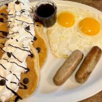 Chocolate Chip Pancake Combo · Three buttermilk pancakes filled with Ghirardelli chocolate chips. Topped with whipped cream...