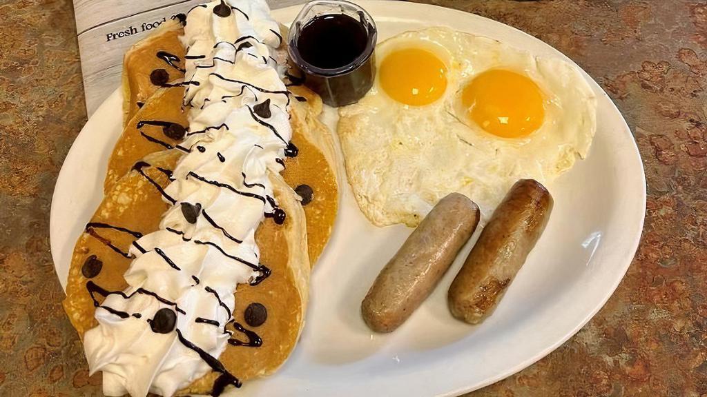 Chocolate Chip Pancake Combo · Three buttermilk pancakes filled with Ghirardelli chocolate chips. Topped with whipped cream and drizzled with chocolate sauce. Served with 2 eggs and your choice of meat.