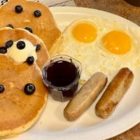 Blueberry Pancake Combo · Three buttermilk pancakes loaded with blueberries. Served with two eggs and your choice of h...