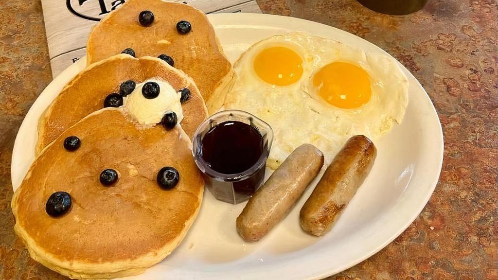 Blueberry Pancake Combo · Three buttermilk pancakes loaded with blueberries. Served with two eggs and your choice of ham, bacon or sausage.