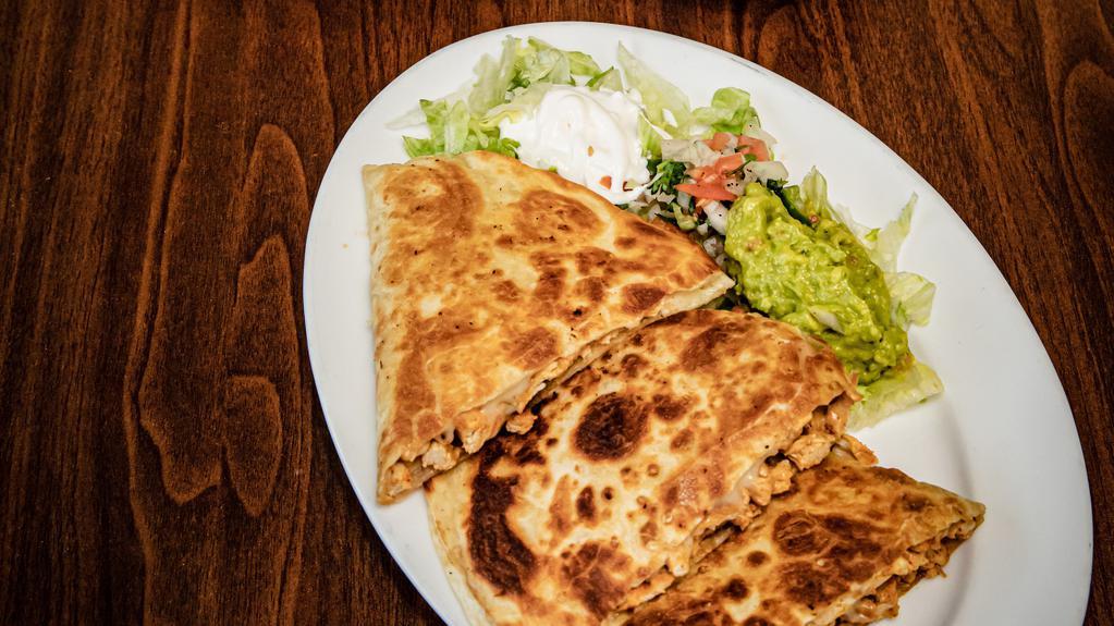Steak Quesadilla · Flour tortilla stuffed with meat and melted cheese and served with lettuce sour cream pico de gallo and guacamole.