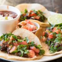 Grilled Steak Tacos · Three soft corn tortilla filled with grilled steak, onion, pico de gallo and cilantro with r...