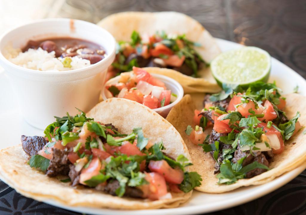 Grilled Steak Tacos · Three soft corn tortilla filled with grilled steak, onion, pico de gallo and cilantro with rice and beans mixed on the side.