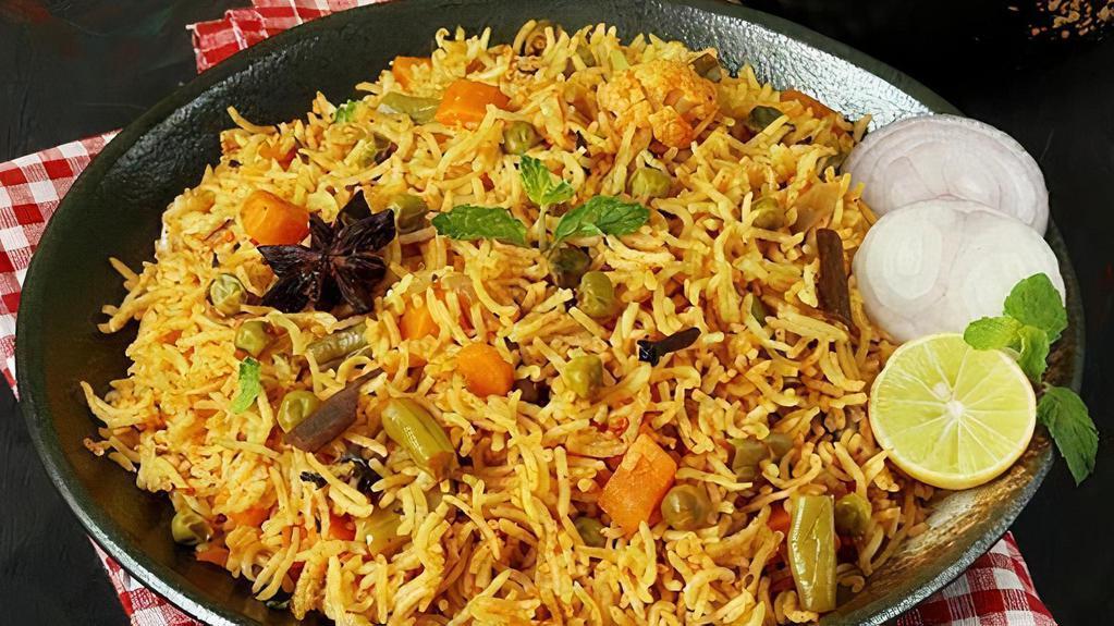 Vegetable Biryani · Biryani is a delicious dish served in and around India. These dishes are made by cooking basmati rice with Veg, yogurt, spices & herbs. Vegetable Biryani is made by a combination of garden-fresh vegetables marinated with herbs, spices, and nuts in basmati rice. Served with raita (yogurt sauce).