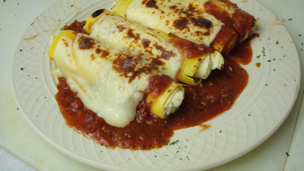 Baked Manicotti · Tender crepe pasta stuffed with a seasoned ricotta cheese and baked in marinara sauce, topped with mozzarella cheese.