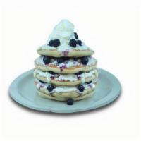 Lemon Ricotta Blueberry Pancakes · Buttermilk pancakes filled with blueberries, layered with lemon-flavored ricotta. Topped wit...