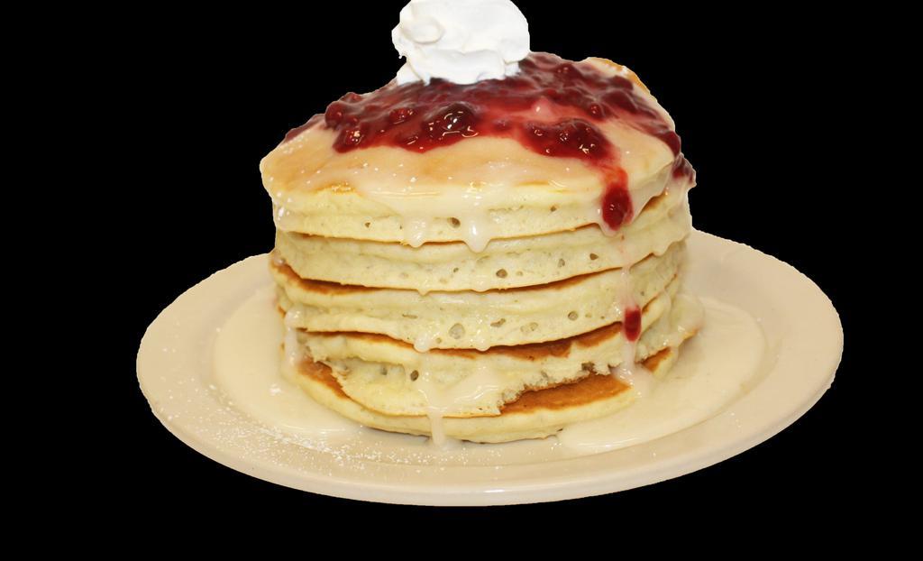 Donut Pancakes · Buttermilk pancakes layered with Donut icing. Topped with powdered sugar, whipped cream, and a drizzle of strawberry Topping.
