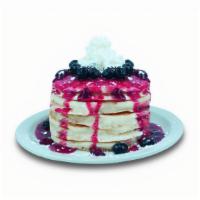 Berries Pancakes · Buttermilk pancakes filled with blueberries. Topped with blueberries, strawberry glaze, whip...