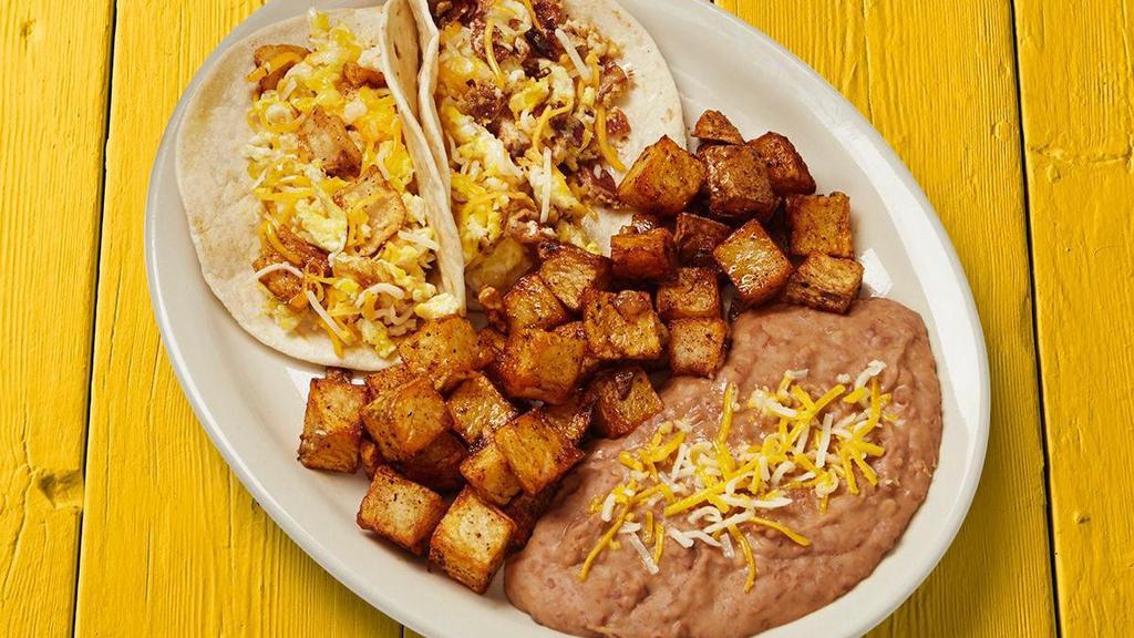 Breakfast Taco Plate · Your choice of two breakfast tacos. Served with Latin-fried potatoes and refried beans.. {GF - select 2 gluten free breakfast tacos with soft corn or crispy corn tortillas and 2 gluten free sides}, {DF - select 2 dairy free breakfast tacos remove shredded cheese and 2 dairy free sides}