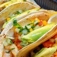 Cajun Shrimp Tacos · Four tacos with flour tortillas filled with Cajun grilled shrimp and topped chipotle mango s...