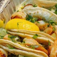 Traditional Shrimp Taco · Four taco with com tortilla filled with grilled shrimp topped with cilantro and chopped onion.