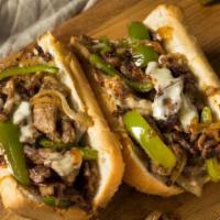 Mediterranean Cheesesteak · Steak sandwich with lettuce, tomato, grilled peppers, and white sauce.