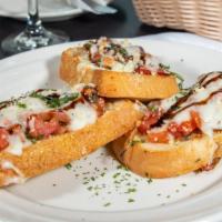 Bruschetta Alla Bella · Three slices of our garlic bread topped with fresh tomatoes, onions, mozzarella cheese and h...