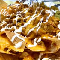 Loaded Nachos · Homemade tortilla chips with blended cheese and your choice of meat, served with homemade gu...