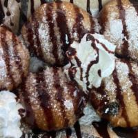 Fried Oreos · Topped with a sprinkle of powdered sugar and a drizzle of chocolate syrup.