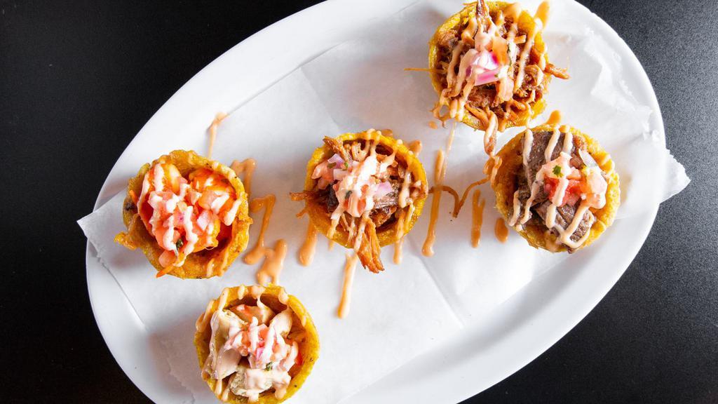 Tostone Cups · Five stuffed, mini tostone cups. Two pernil, one beef, one chicken and one shrimp, topped with pico de gallo and mayo-ketchup sauce.
