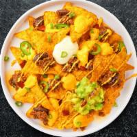 Nacho Supreme · Salted tortilla chips doused with chili, beans, queso, cheddar cheese, lettuce, tomato, onio...