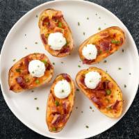 Meaty Melts Potato Skins · (6 pieces) Baked potato skins filled with cheddar cheese, bacon, and chives. Served with sou...