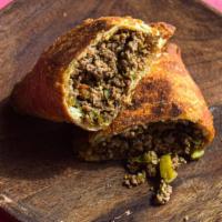 Picadillo Beef Empanada · Ground beef with a hint of cinnamon, spices, onions, raisins, diced olives.
