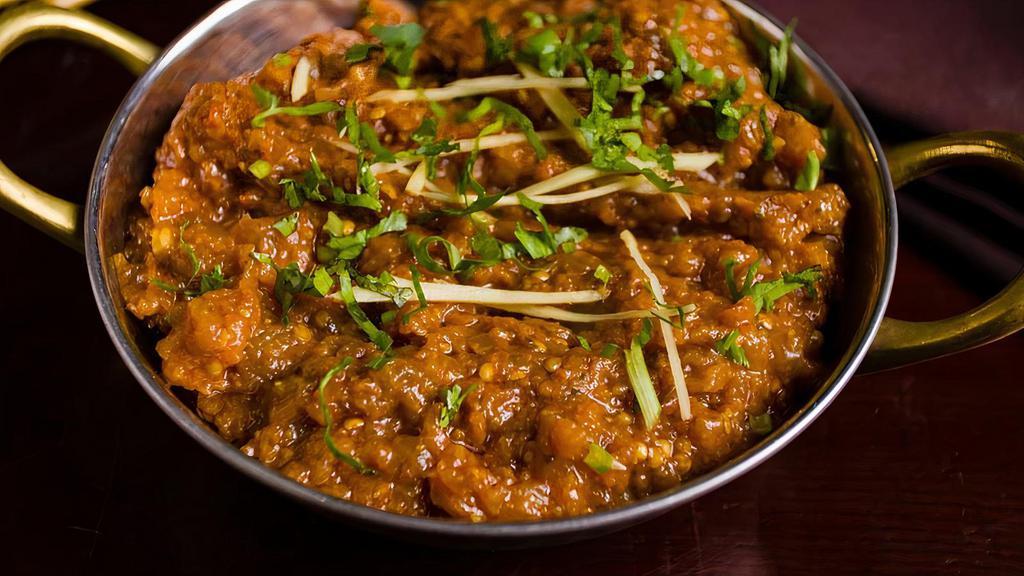 Baingan Bharta · Eggplant smoked in tandoor, minced, and prepared with onions, tomatoes, and garden herbs topped with ginger and cilantro.
